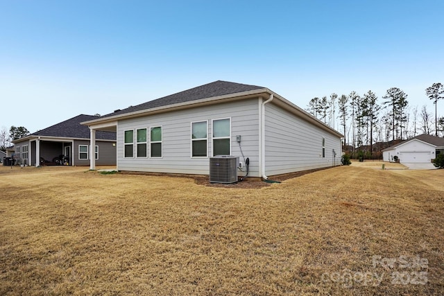 rear view of property featuring a yard and central air condition unit