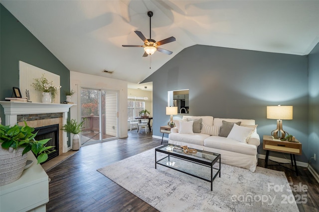 living room featuring a tiled fireplace, high vaulted ceiling, dark hardwood / wood-style floors, and ceiling fan