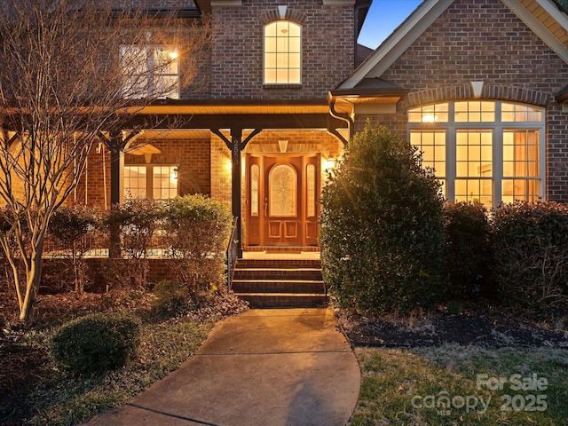 view of exterior entry with brick siding