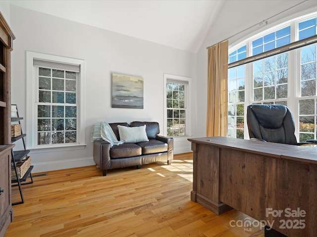 home office with lofted ceiling, light wood finished floors, and baseboards