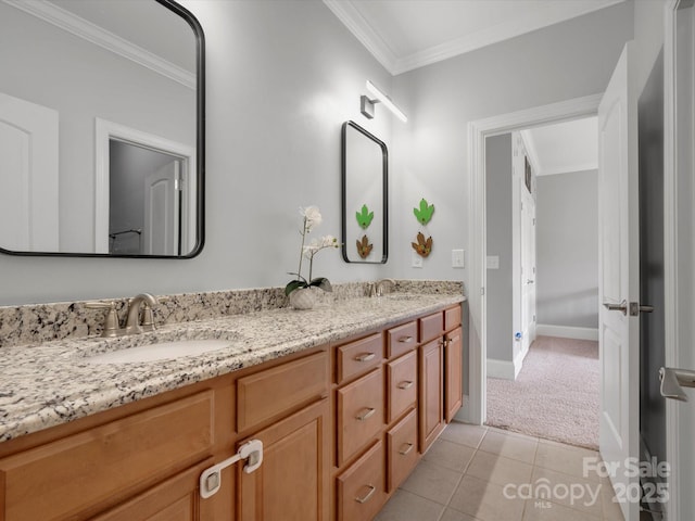 bathroom with tile patterned flooring, a sink, baseboards, ornamental molding, and double vanity