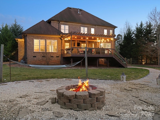 back of house with an outdoor fire pit, stairway, crawl space, a deck, and brick siding