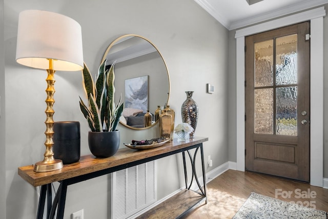 foyer entrance featuring ornamental molding, a wealth of natural light, and light hardwood / wood-style flooring