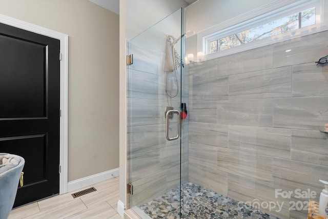 bathroom featuring a shower with shower door