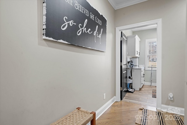 hallway featuring ornamental molding and light wood-type flooring