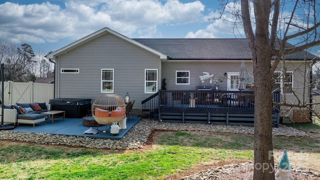 rear view of property with a patio area, a hot tub, outdoor lounge area, and a deck