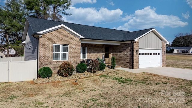 view of front of home featuring a garage, a front yard, and covered porch