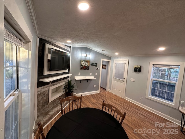 dining area with ornamental molding, lofted ceiling, and hardwood / wood-style floors