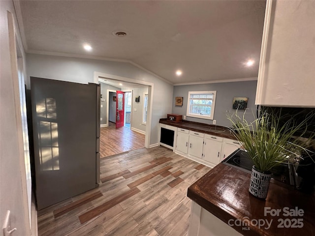 living room featuring lofted ceiling, crown molding, and light wood-type flooring