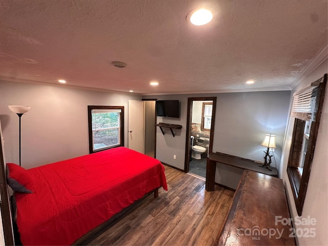 bedroom featuring ensuite bath, dark wood-type flooring, ornamental molding, and a textured ceiling