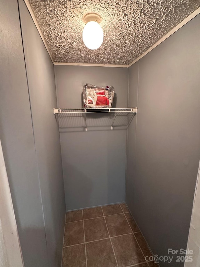 spacious closet with dark tile patterned flooring