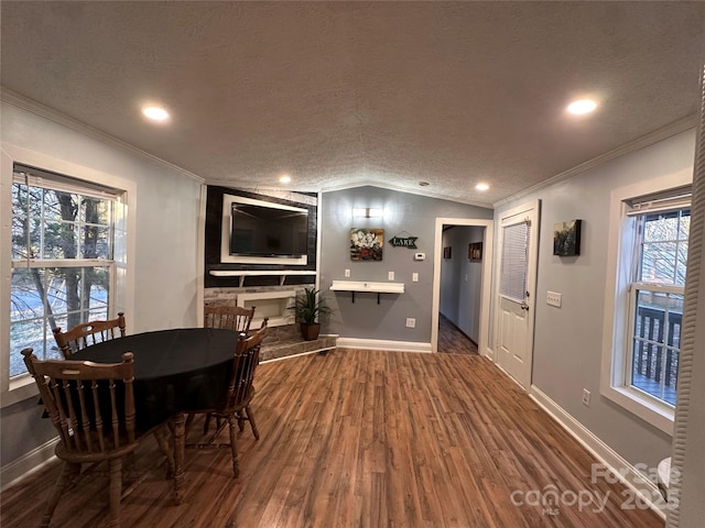 dining area featuring crown molding, vaulted ceiling, hardwood / wood-style floors, and a textured ceiling