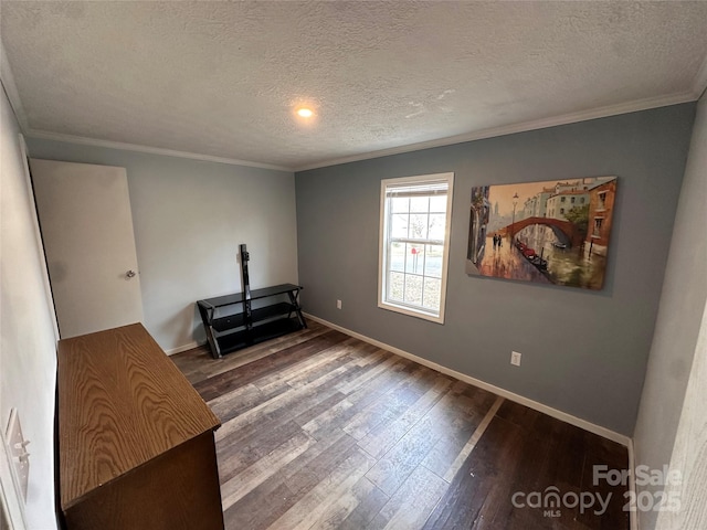 empty room featuring ornamental molding, dark wood-type flooring, and a textured ceiling