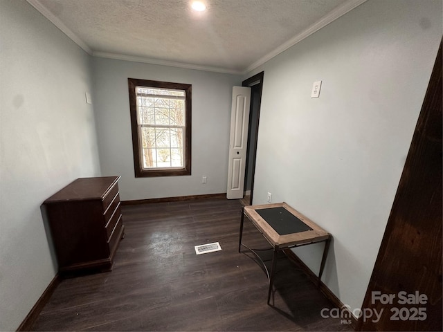 interior space featuring dark hardwood / wood-style flooring, ornamental molding, and a textured ceiling