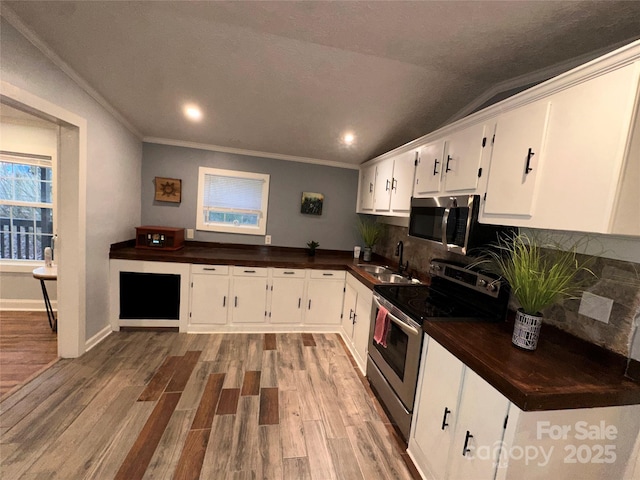 kitchen with white cabinetry, sink, decorative backsplash, hardwood / wood-style flooring, and stainless steel appliances