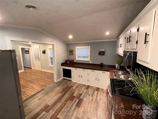 kitchen with white cabinetry, light wood-type flooring, a textured ceiling, and appliances with stainless steel finishes