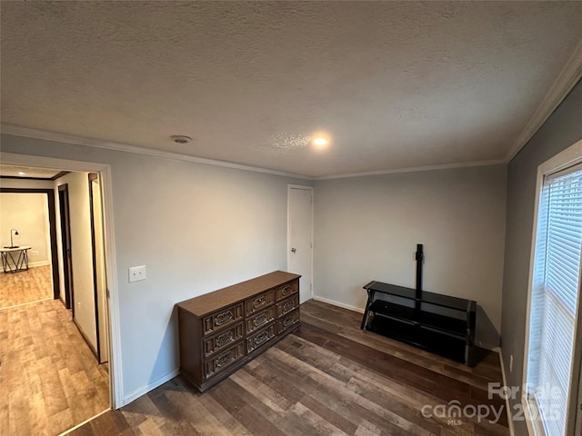 interior space featuring hardwood / wood-style flooring, ornamental molding, and a textured ceiling