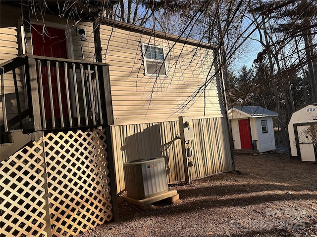 view of property exterior featuring cooling unit and a shed