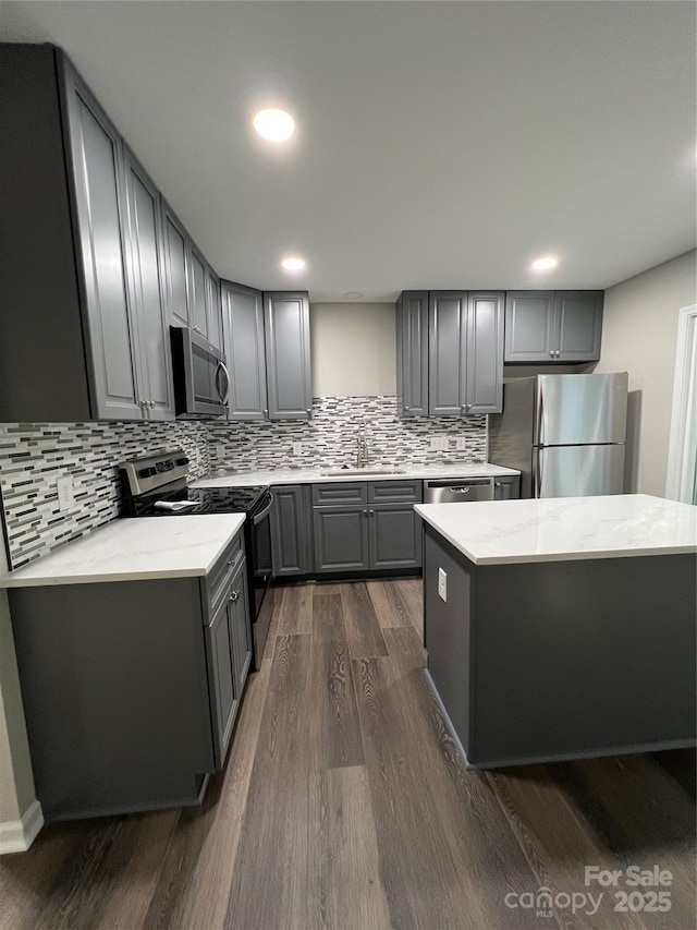 kitchen featuring appliances with stainless steel finishes, sink, gray cabinetry, and dark hardwood / wood-style flooring