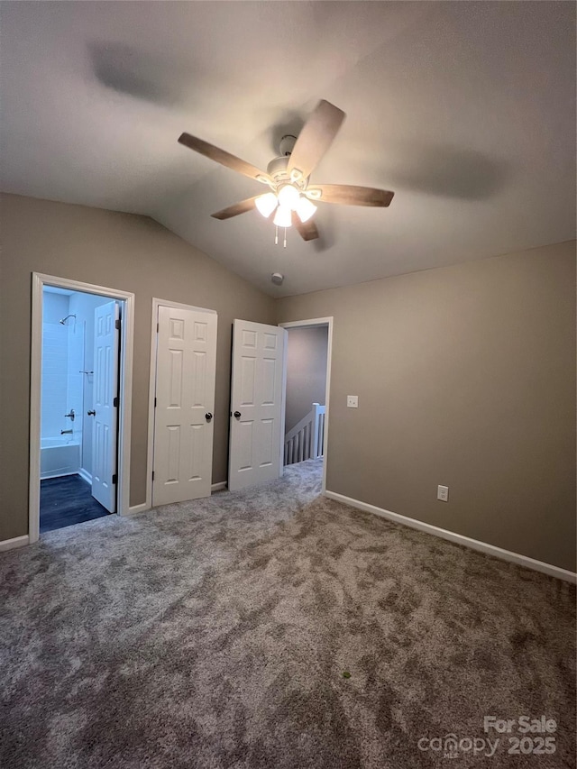 9103 Exbury Ct, Charlotte, NC 28269 - unfurnished bedroom featuring connected bathroom, vaulted ceiling, ceiling fan, and dark colored carpet