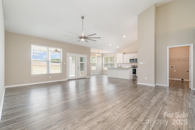 unfurnished living room featuring high vaulted ceiling, a wealth of natural light, and light hardwood / wood-style floors