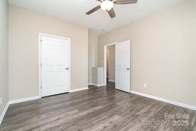 unfurnished bedroom featuring ceiling fan and dark hardwood / wood-style flooring