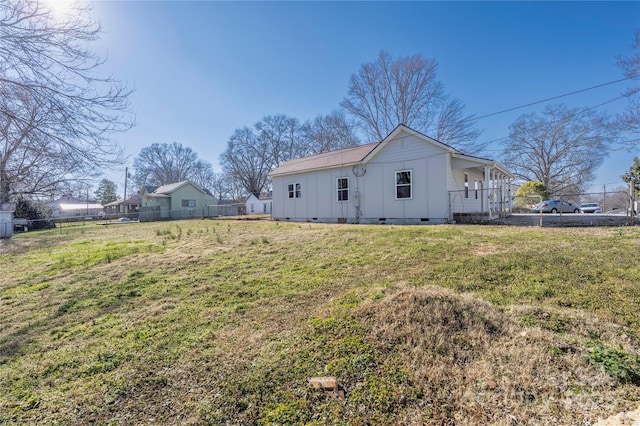 rear view of property with a yard, crawl space, fence, and board and batten siding