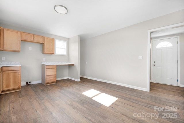 kitchen with light brown cabinets, baseboards, light countertops, and wood finished floors