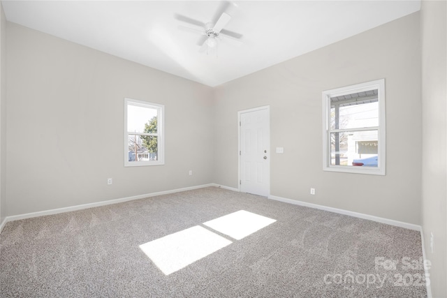 spare room featuring baseboards, carpet flooring, a ceiling fan, and a healthy amount of sunlight