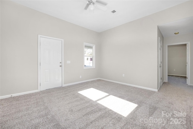 empty room with ceiling fan, carpet floors, visible vents, and baseboards