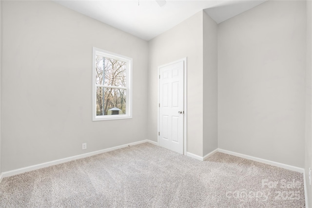 unfurnished room featuring carpet and baseboards