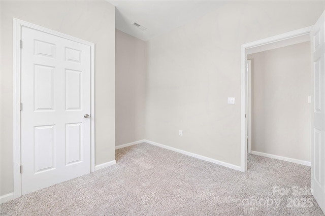 unfurnished bedroom featuring carpet, visible vents, and baseboards