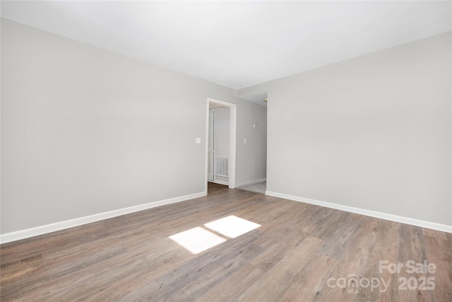 unfurnished room featuring baseboards and wood finished floors