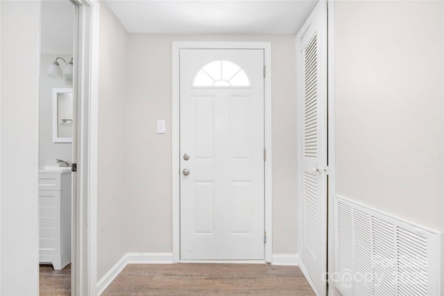 entrance foyer with baseboards, visible vents, and wood finished floors