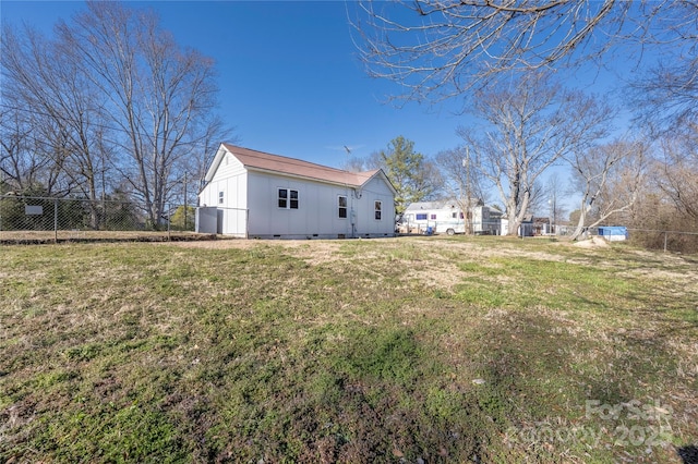 exterior space featuring crawl space, fence, and a lawn