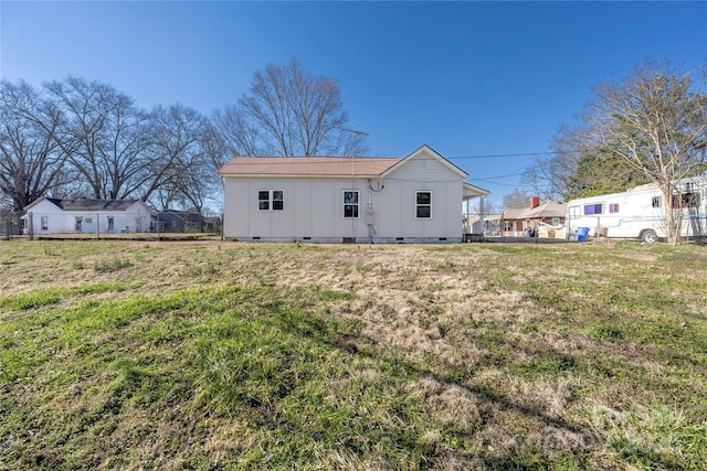 rear view of house with crawl space and a yard