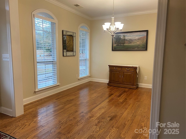 unfurnished dining area with dark hardwood / wood-style flooring, a notable chandelier, plenty of natural light, and ornamental molding