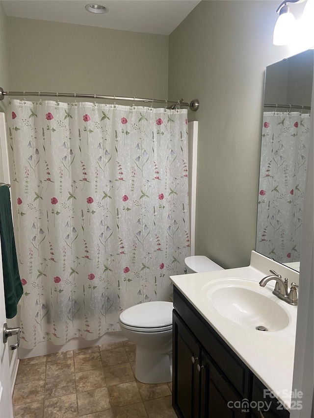 full bathroom featuring vanity, shower / bath combo with shower curtain, and toilet