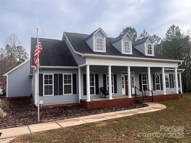 cape cod-style house featuring a front yard and covered porch