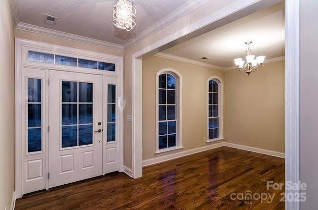 entryway with dark wood-type flooring, crown molding, and a notable chandelier