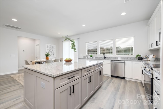 kitchen featuring visible vents, light wood finished floors, a kitchen island, recessed lighting, and stainless steel appliances