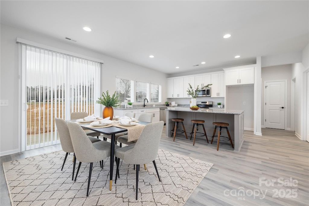dining space with recessed lighting, visible vents, light wood finished floors, and baseboards