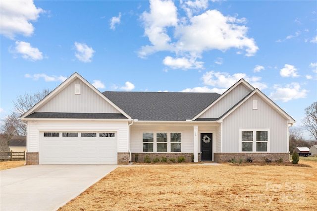 view of front of house with brick siding, driveway, an attached garage, and roof with shingles