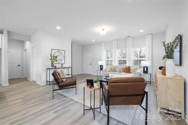 living area with recessed lighting, baseboards, and light wood finished floors