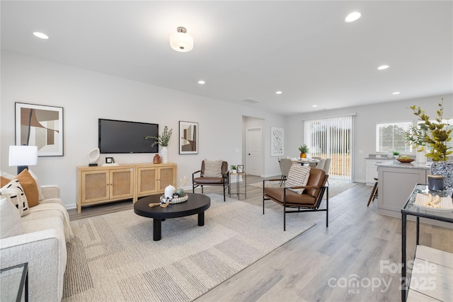 living area with recessed lighting, light wood-style flooring, and baseboards