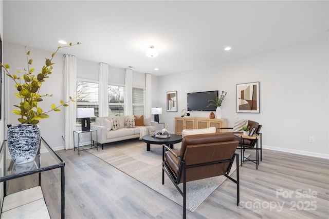 living area featuring recessed lighting, baseboards, and light wood-style floors