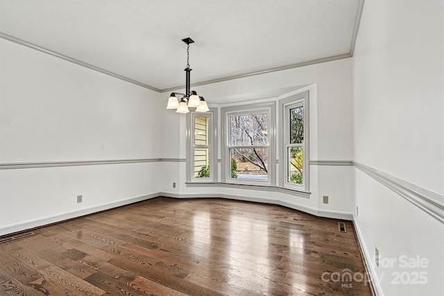 unfurnished dining area with crown molding, dark hardwood / wood-style floors, and a chandelier