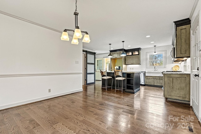 kitchen featuring backsplash, a center island, dark hardwood / wood-style flooring, decorative light fixtures, and a barn door