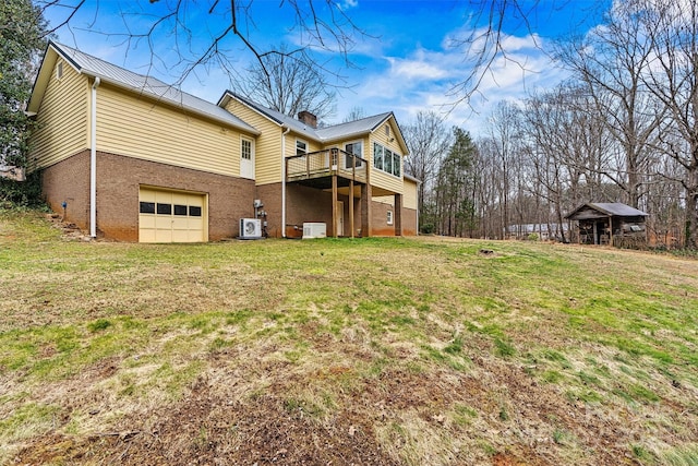 back of house featuring a garage and a yard