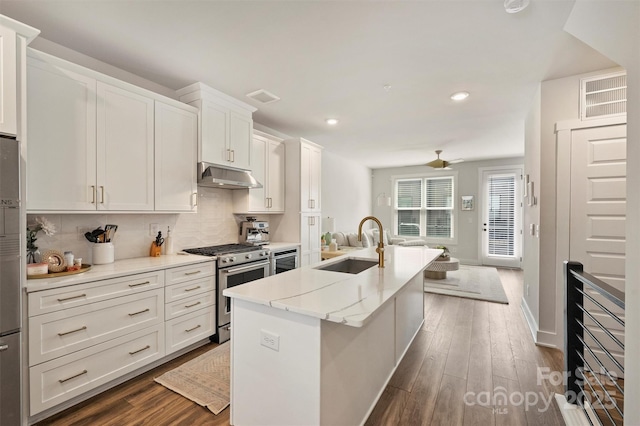 kitchen featuring stainless steel appliances, white cabinetry, a kitchen island with sink, and sink